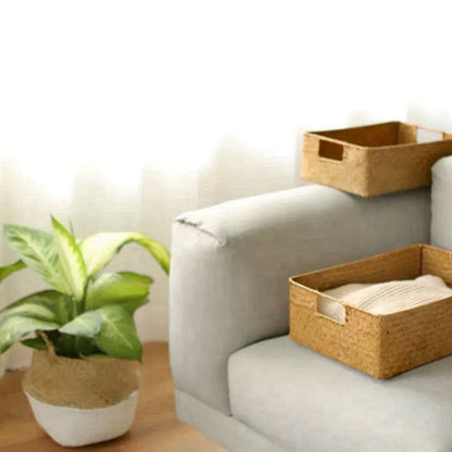 Light gray sofa with woven baskets and a plant in a room.
